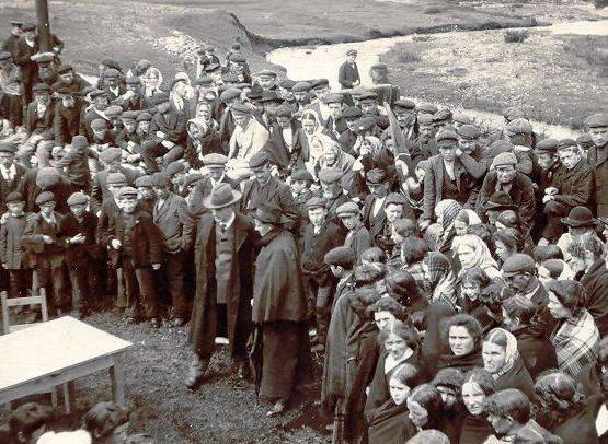 A Gaelic League aeraiocht (an outdoor festival of music, dance, and recitation) in Rosmuc, Co. Galway, c.1905. Pearse is standing to the front wearing a grey hat and a long black overcoat. OPW.